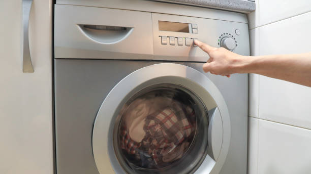 istock Selective focus of man hand which push button switch on washing machine 1247026157