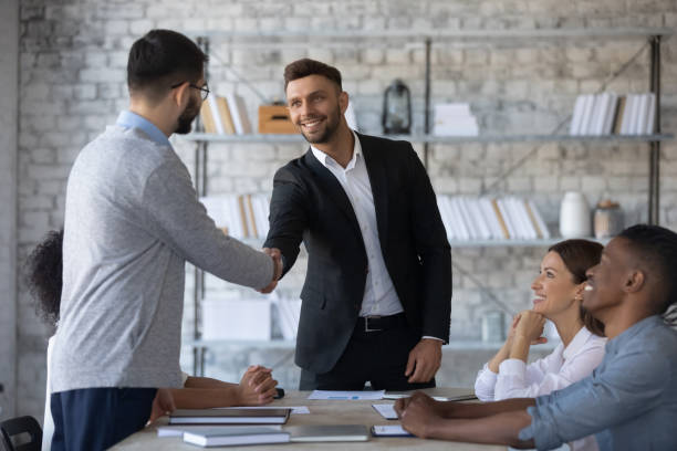 istock Smiling executive shaking successful employee hand at corporate meeting 1247026201