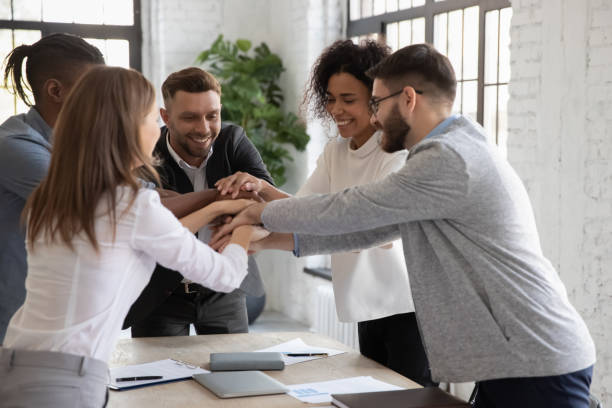 istock Successful diverse employees stacking hands, engaged in team building 1247026231