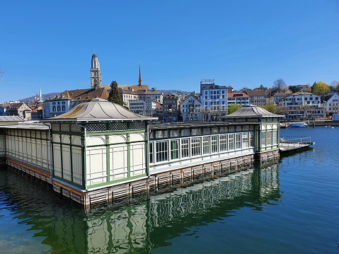 Zurich city with the river Limmmat and a old puplic bath. The image was captured during springtime on a sunny day.