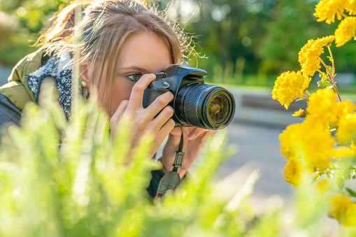 a young woman takes nature photos in a park