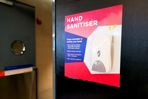 A hand sanitizer dispenser near at emergency exit door in shopping mall to encourage shoppers maintaining personal hygiene in Malaysia.