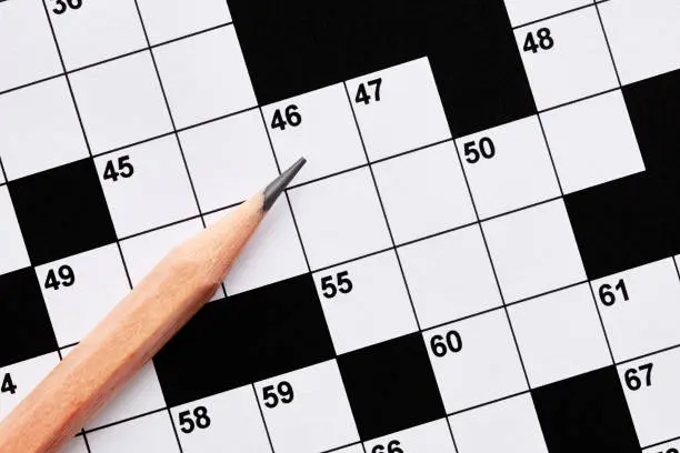 Blank crossword puzzle game with pencil. Overhead close up view.