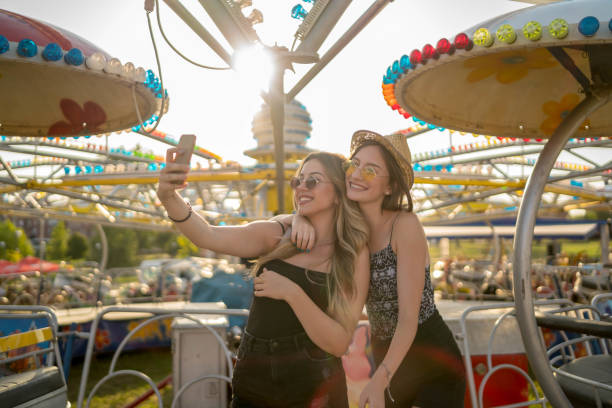 istock Happy girlfriends are make fun together in fun fair 1247032240