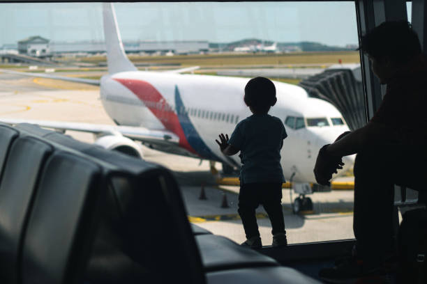 Airport Silhouette A 2 year-old toddler enthusiastically observing an airplane in KLIA. kuala lumpur airport stock pictures, royalty-free photos & images