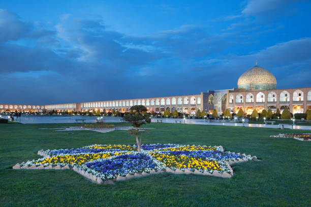 Illuminated Sheikh Lotfollah Mosque and Naqshe Jahan Square of Isfahan against Blue Sky Before Night stock photo