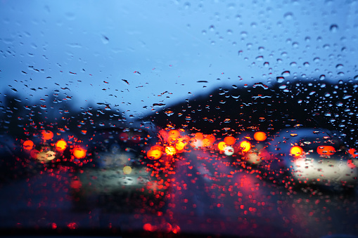 Motorway traffic jam caused by an accident on a wet road. View through a rainy windscreen to the roadway