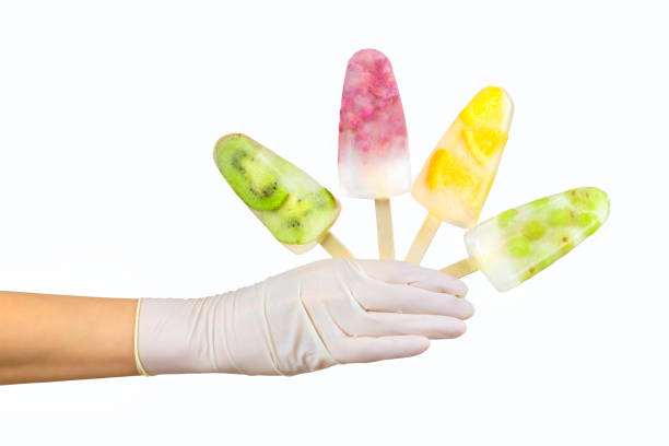 Gloved hand holding four fruit popsicles. Summer season concept