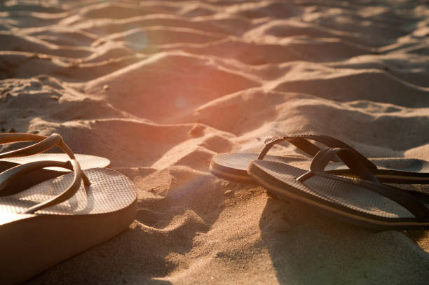 istock beach sandals on fine sand at sunset 1247066271