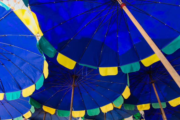 istock Blue beach umbrellas for sun protecrion closeup background. 1247070221