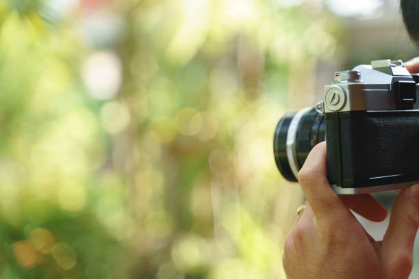 istock Hand holding retro 35mm film camera 1247073858