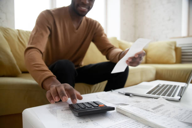 istock African ethnicity man calculates digits using calculator planning family budget 1247084232