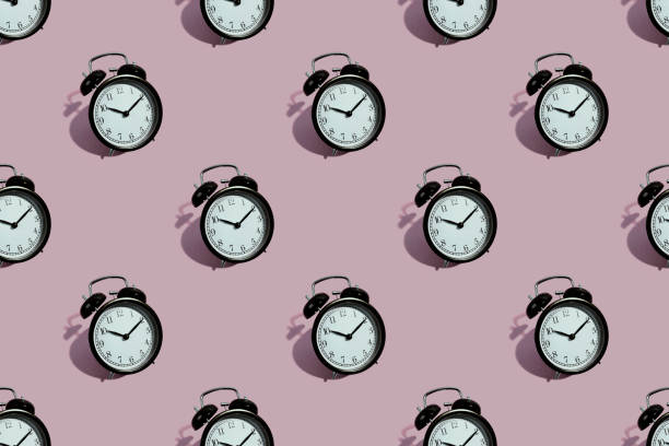 istock Many black classic style alarm clock isolated on pink background 1247110908
