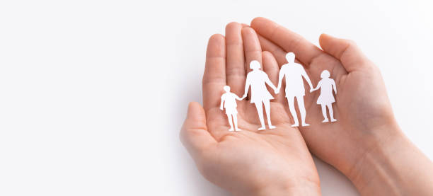 istock Family care concept. Hands with paper silhouette on table. 1247171977