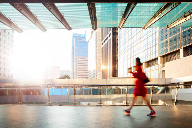 Blurred motion businesswoman walking at pedestrian walkway at dawn Blurred motion businesswoman walking at pedestrian walkway at dawn central district hong kong stock pictures, royalty-free photos & images