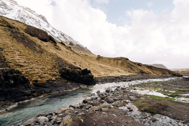 istock A shallow mountain river with blue azure water flows against the backdrop of mountains into the mth and snow-capped peaks. 1247234700
