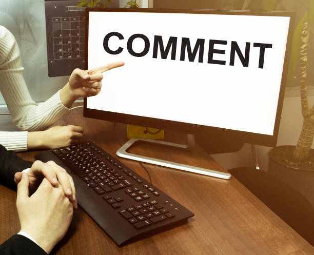 istock male and female hand, computer with text COMMENT with office background 1247235421