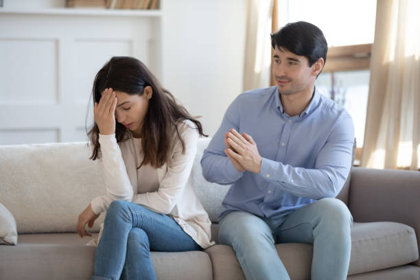 joven pide perdón a la infeliz amada mujer - pleading men women forgiveness fotografías e imágenes de stock