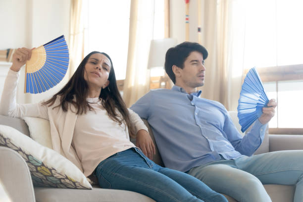 istock Overheated couple suffer from heatstroke using wavers 1247241920
