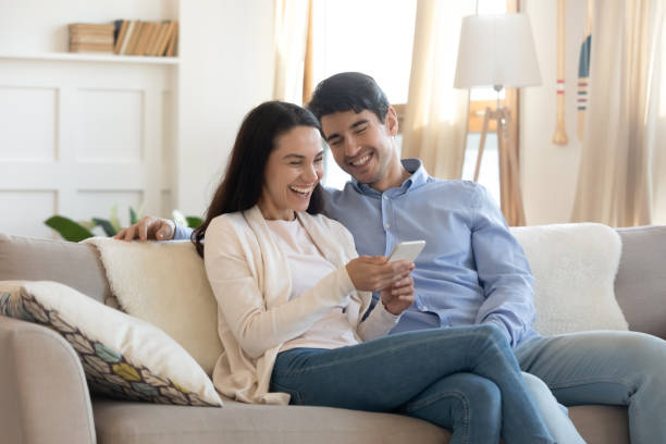 istock Overjoyed couple have fun using smartphone together 1247241924
