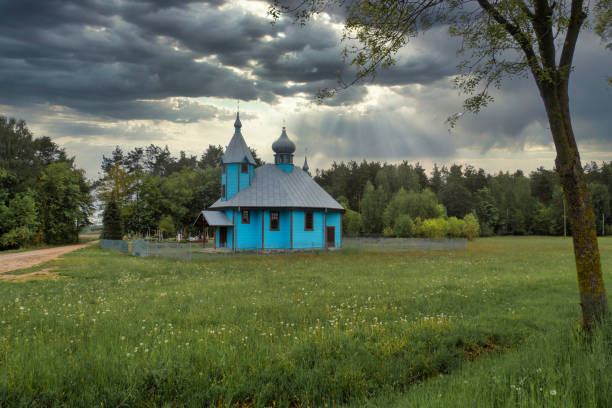 Old weathered small wooden chapel isolated in beautiful countryside landscape. Horizontal color photography.