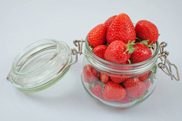 istock fresh srawberry in a glass jar on a white background 1247259645