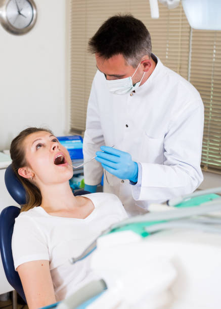 istock Dentist is treating visitor which is sitting in dental chair 1247299921