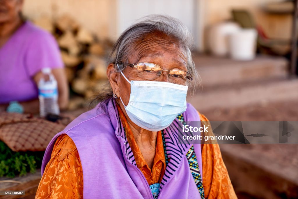 Aged Grandmother Navajo Woman Wearing a Mask to Prevent the Spread of the Corona Virus or Covi-19 Coronavirus Stock Photo