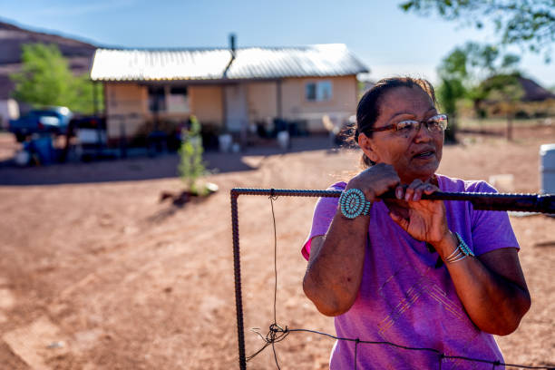 Elderly Navajo Woman at a Gate in front of her house in Monument Valleya Elderly Navajo Woman at a Gate in front of her house in Monument Valleya navajo nation covid stock pictures, royalty-free photos & images