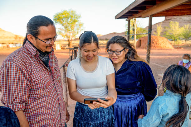 familia navajo pasar tiempo compartiendo fotos desde un teléfono inteligente - navajo fotografías e imágenes de stock