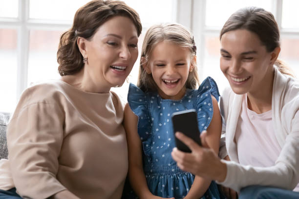 istock Happy three generations of women have fun using cellphone 1247334256