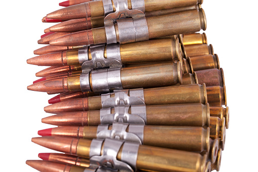 A belt of .50 calibre machine gun rounds, some of which are tracer rounds signified by the red tips.