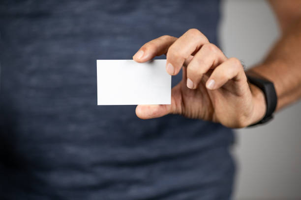 istock Man holding a business card sized blank paper. Selective focus. 1247364403