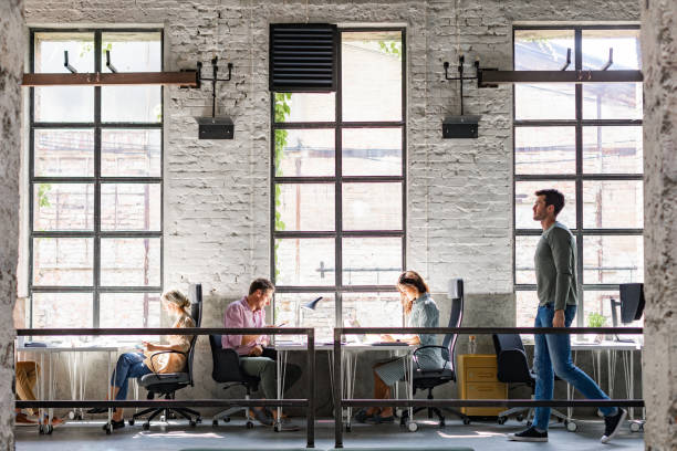 istock Wide Angle View of a Modern Loft Open Space Office With Businesspeople Working in It  (Copy Space) 1247371850
