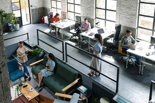Vista gran angular de una oficina de espacio abierto Loft moderno con empresarios que trabajan en ella photo