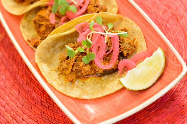 istock Tacos with pork and onion, lime on a pink plate. 1247372149