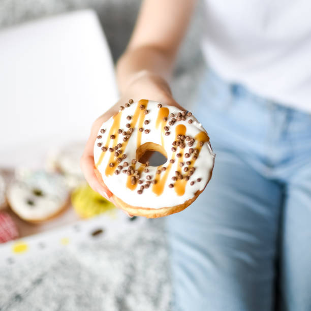 istock Female hand holding delicious donut 1247387054