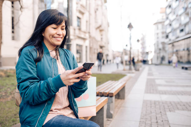 istock Happy Asian using phone after shopping 1247387596