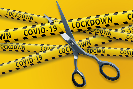 The end of the Covid 19 pandemic. Scissors cut yellow ribbons with text Covid-19 LOCKDOWN