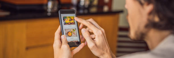 istock man orders food for lunch online using smartphone BANNER, LONG FORMAT 1247429110