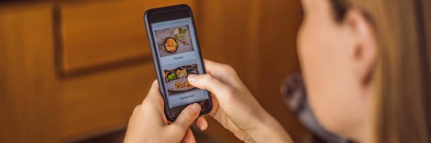 istock Young woman orders food for lunch online using a smartphone BANNER, LONG FORMAT 1247429112