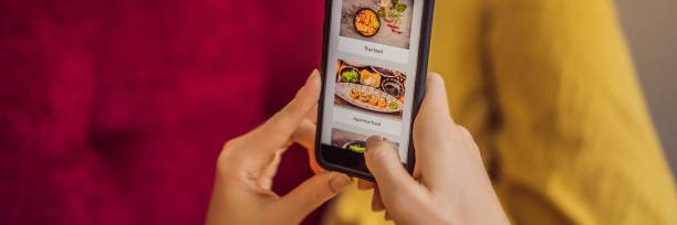 istock Young woman orders food for lunch online using a smartphone BANNER, LONG FORMAT 1247429434