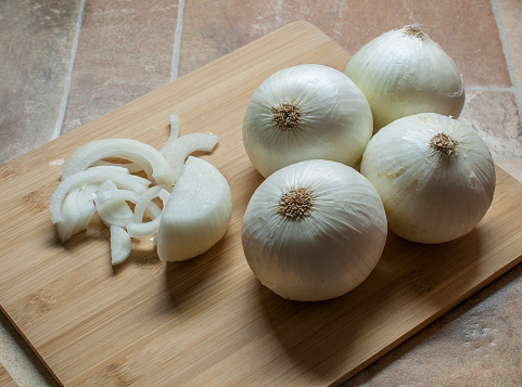 White onions on a wooden cutting board