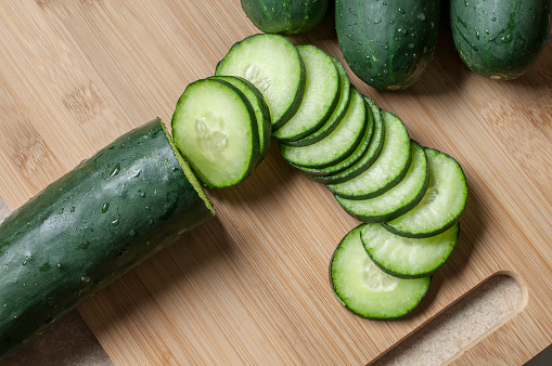 Fresh cucumber slices on a wooden cutting board