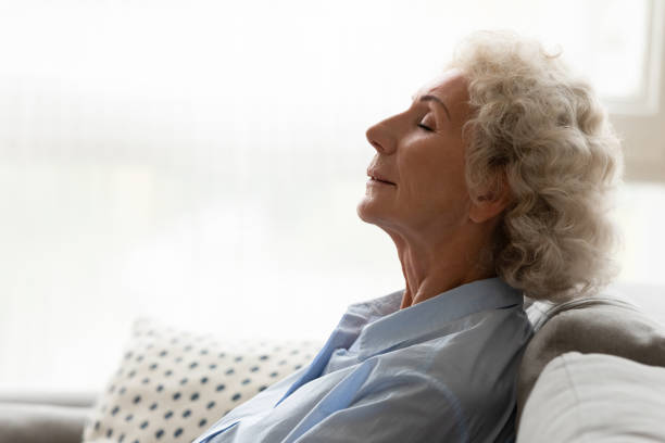istock Peaceful old woman leaned on couch breathing fresh conditioned air 1247568840