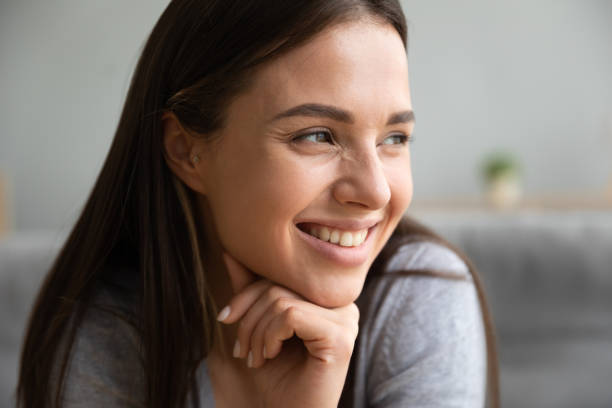 istock Close up image smiling positive young woman face 1247568849