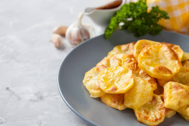 istock potatoes baked by slices in a plate on a table, selective focus 1247573525