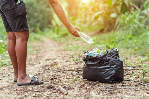 istock A man Keep garbage in the forest. Save the world concept. 1247587624