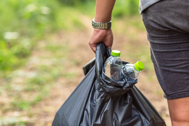 istock A man collects garbage in the forest. Protect the nature concept. 1247587635