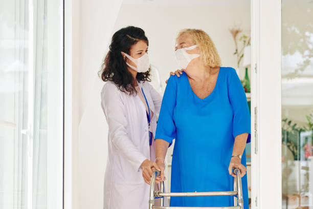 istock Caregiver helping senior woman 1247590450